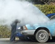 Man looking at a smoking engine in his car