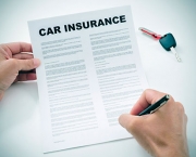 man signing a car insurance policy