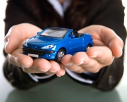 businesswoman holding car in the hands - insurance or car business concept