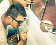 Young handsome man with sunglasses inspecting a vintage car body at second hand trade - Passion and transportation lifestyle of a retro classic vehicles collector
