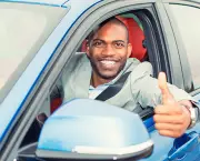 Man driver happy showing thumbs up coming out of car